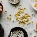 Variety of capsules and pills displayed in bowls on a marble table, ideal for healthcare concepts.